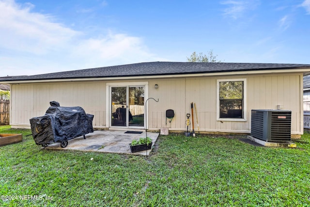 back of house with central AC unit, a patio, and a yard