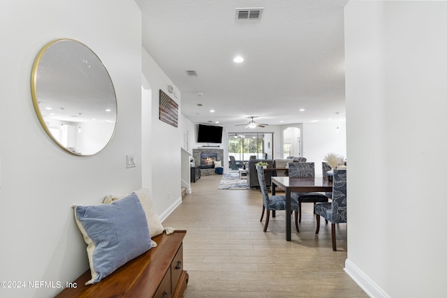 dining area featuring light wood-type flooring, a fireplace, visible vents, and recessed lighting