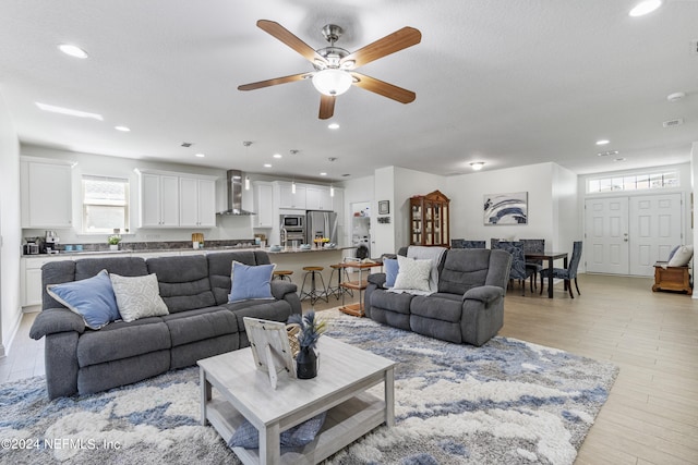 living area with a ceiling fan, recessed lighting, and light wood-type flooring