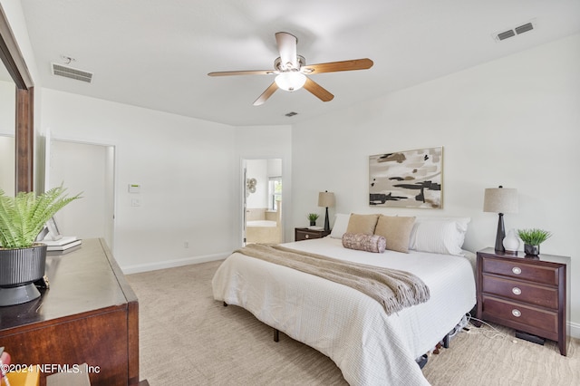 bedroom featuring ensuite bath, baseboards, visible vents, and light colored carpet