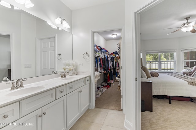 ensuite bathroom with ensuite bathroom, a spacious closet, tile patterned flooring, and a sink