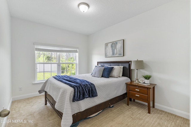 bedroom with light carpet and baseboards