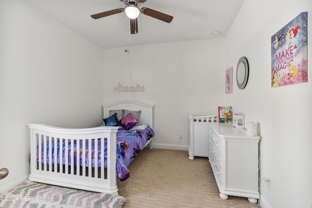 bedroom with light colored carpet, a ceiling fan, and baseboards