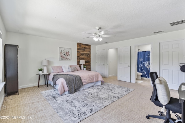 bedroom featuring visible vents, a textured ceiling, and light colored carpet