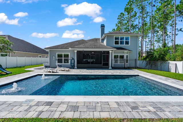 rear view of property with a patio area, a sunroom, a fenced backyard, and a chimney