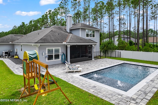 back of property with a fenced in pool, pool water feature, a yard, and a patio