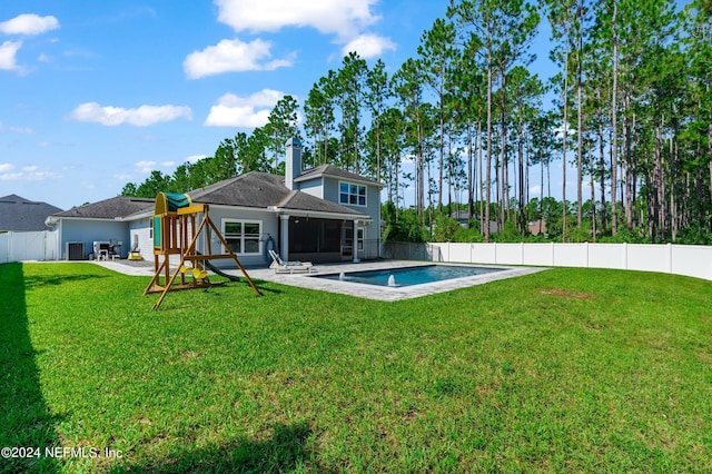 rear view of house featuring a fenced in pool, a lawn, a sunroom, a fenced backyard, and a playground