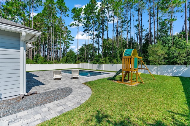 view of jungle gym with a yard, a patio, a fenced backyard, and a fenced in pool