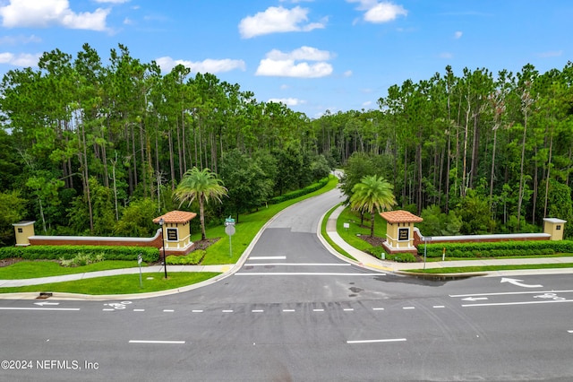 view of street with sidewalks, traffic signs, a view of trees, and curbs