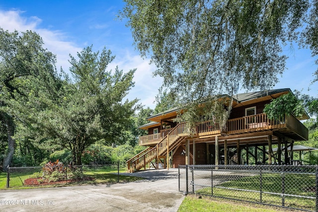 view of front of home featuring driveway, fence, and stairs