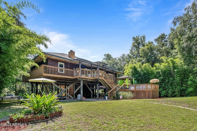 back of property featuring a deck and a yard