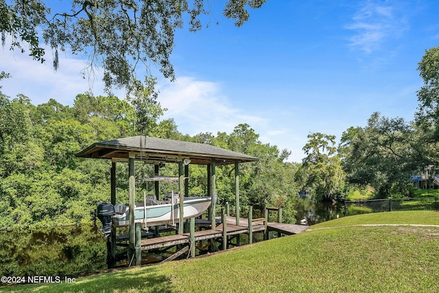 view of dock with boat lift and a yard