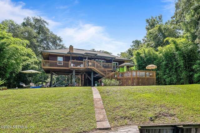 back of house with a wooden deck and a yard