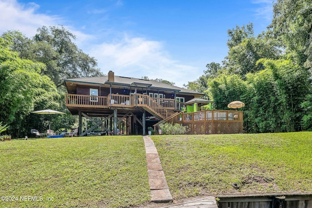 back of house with a wooden deck, stairs, a chimney, and a yard