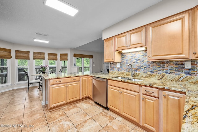 kitchen with a peninsula, a sink, stainless steel dishwasher, backsplash, and light stone countertops