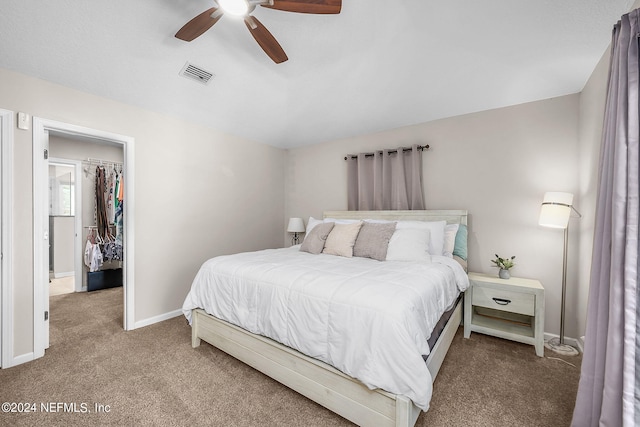 bedroom with ceiling fan, carpet flooring, visible vents, baseboards, and a spacious closet