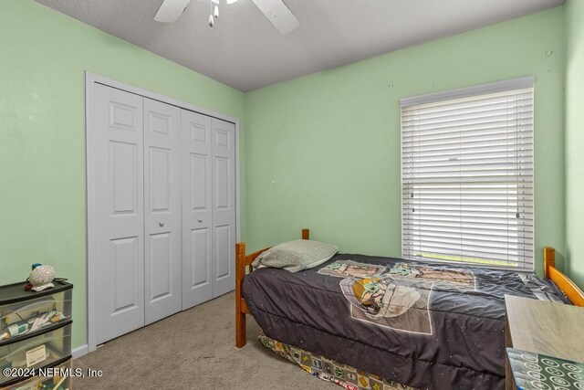 carpeted bedroom with a closet and ceiling fan