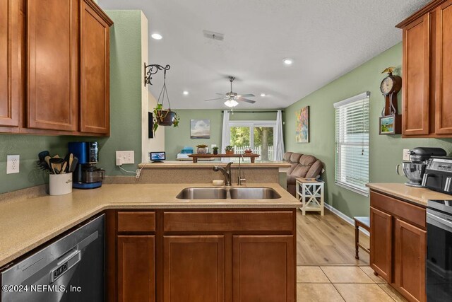 kitchen featuring ceiling fan, light wood-type flooring, sink, kitchen peninsula, and stainless steel appliances