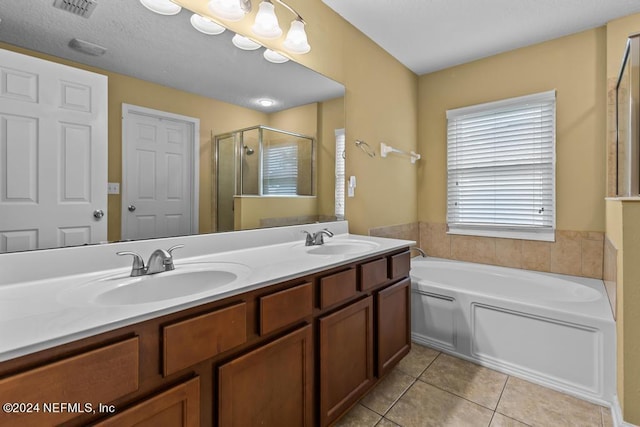 bathroom with tile patterned flooring, separate shower and tub, a textured ceiling, and vanity