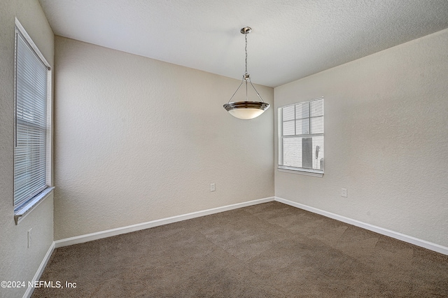 unfurnished room with dark colored carpet