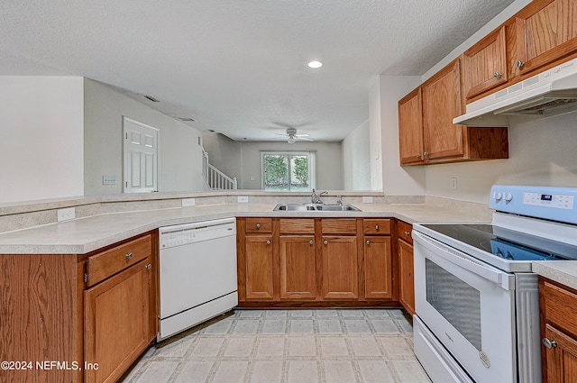 kitchen with sink, light tile patterned floors, kitchen peninsula, white appliances, and ceiling fan