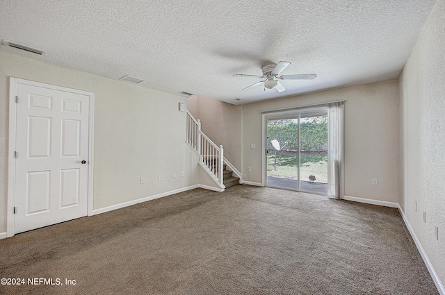 spare room with ceiling fan, a textured ceiling, and dark colored carpet