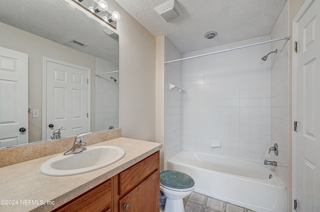 full bathroom with toilet, tile patterned flooring, vanity, a textured ceiling, and tiled shower / bath combo