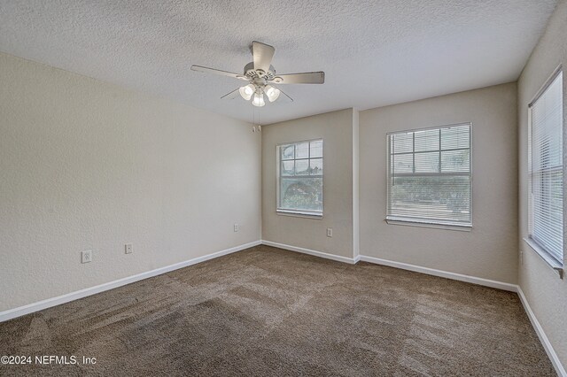 spare room with a textured ceiling, ceiling fan, and carpet