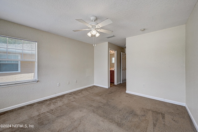 empty room with ceiling fan, a textured ceiling, and carpet flooring