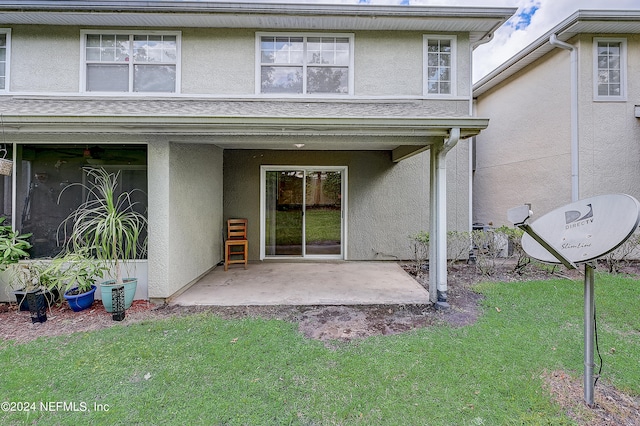 back of house with a lawn and a patio area