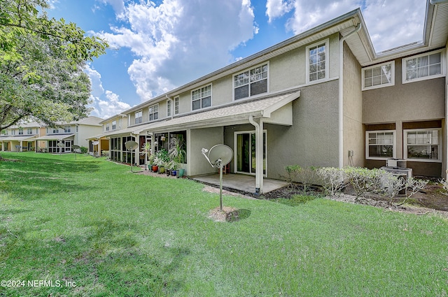 rear view of house with a patio, central AC, and a yard