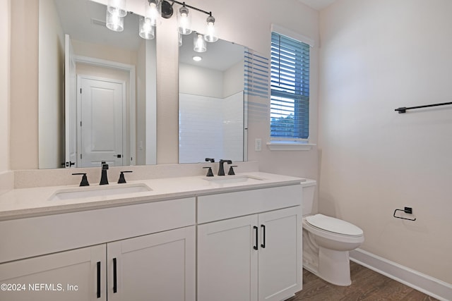 bathroom featuring toilet, hardwood / wood-style floors, vanity, and walk in shower