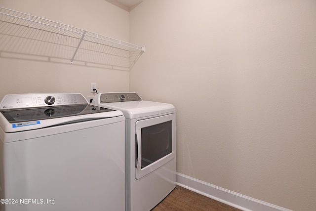 laundry area with dark hardwood / wood-style floors and separate washer and dryer