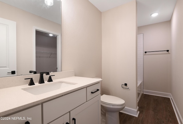 full bathroom with hardwood / wood-style floors, vanity, toilet, and shower / washtub combination