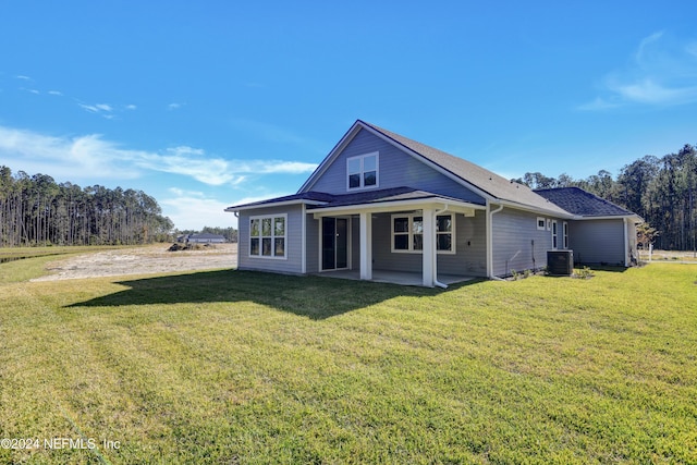 rear view of property with a lawn, a patio area, and central air condition unit