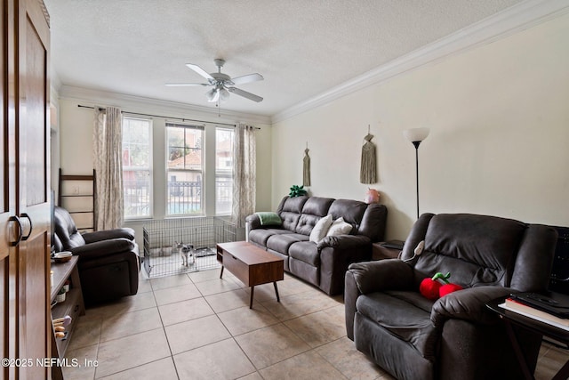 living room featuring ceiling fan, ornamental molding, a textured ceiling, and light tile patterned floors