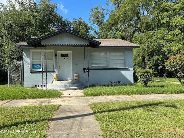 bungalow-style home with a front yard