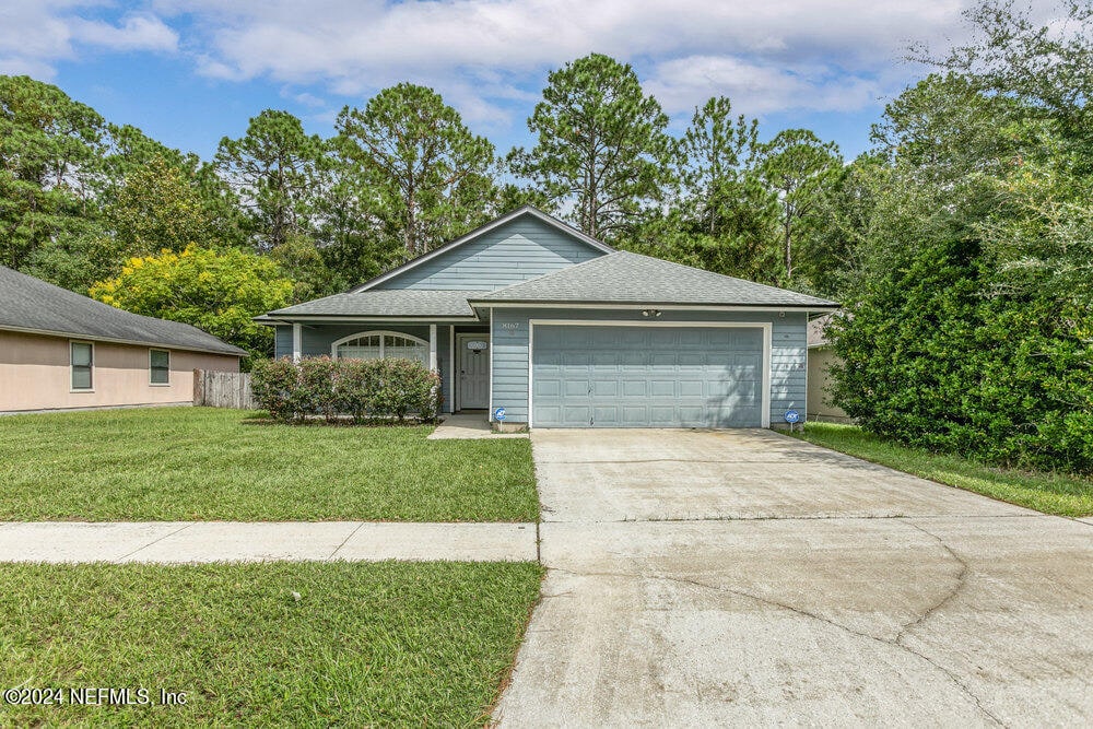 view of front of house with a garage and a front lawn