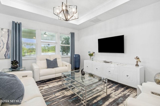 living room with ornamental molding, a raised ceiling, and an inviting chandelier