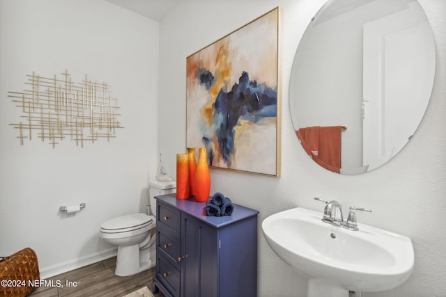 bathroom featuring toilet, hardwood / wood-style flooring, and sink