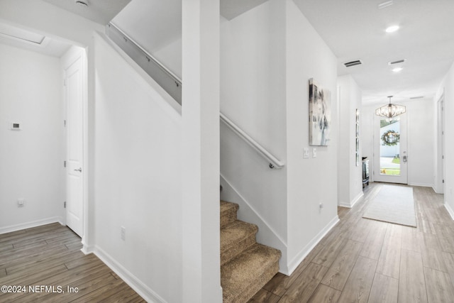 foyer with hardwood / wood-style floors and a chandelier