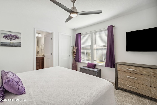 bedroom with ceiling fan, connected bathroom, and light carpet