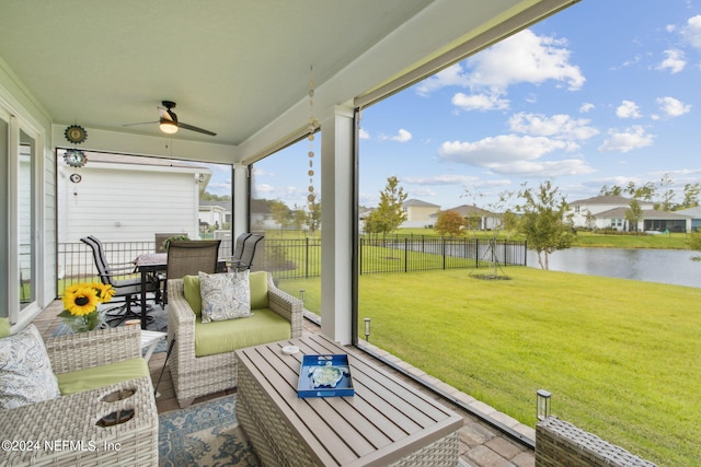 sunroom / solarium with a water view, ceiling fan, and a wealth of natural light