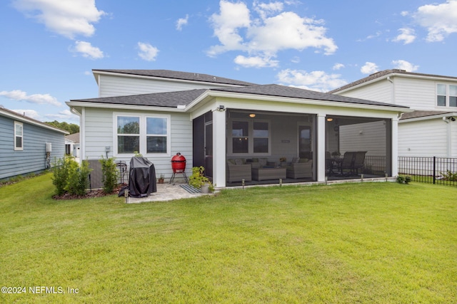 rear view of property featuring a yard, a patio, and a sunroom