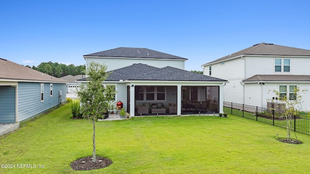 rear view of property with a lawn, a patio, and a sunroom