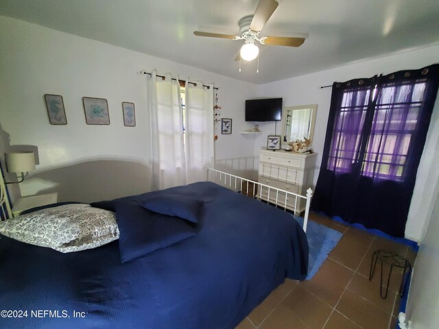 tiled bedroom featuring ceiling fan