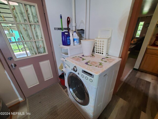 clothes washing area with hardwood / wood-style floors and washer / clothes dryer