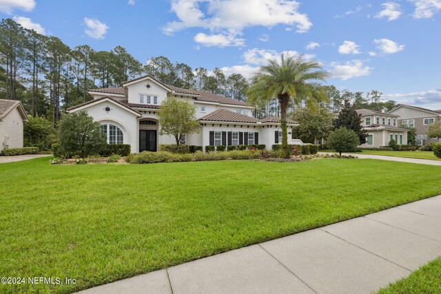 mediterranean / spanish-style home with a front yard