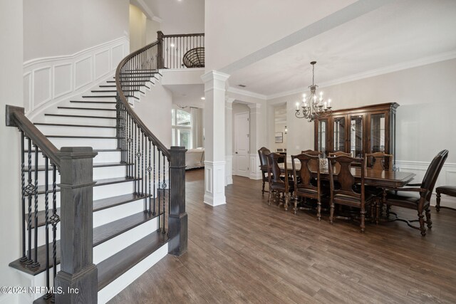 dining room with ornamental molding, dark hardwood / wood-style flooring, a chandelier, and decorative columns