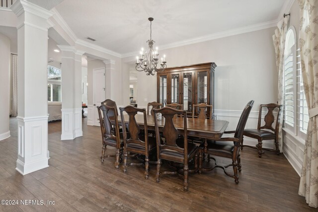 dining space with ornamental molding, dark wood-type flooring, ornate columns, and a notable chandelier